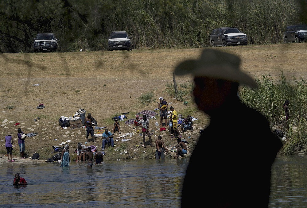 FILE - Migrants, many from Haiti, wade across the Rio Grande from Del Rio, Texas, to return to Ciudad Acuna, some to avoid possible deportation from the United States and others to get supplies, on Sept. 22, 2021. A year into the Joe Biden’s presidency, though, action on the immigration system has been hard to find and there is growing consternation privately among some in the party that the Biden administration can’t find the right balance on immigration. (AP Photo/Fernando Llano, File)