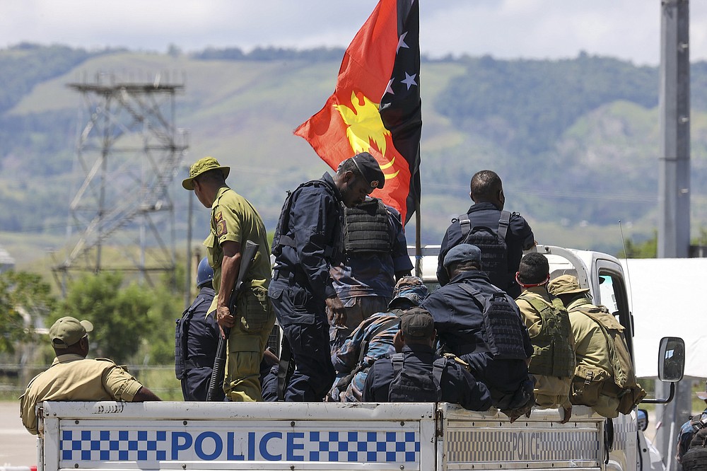 Papua New Guinea police arrive at the airport in Honiara, Solomon Islands, Saturday, Nov. 27, 2021. Solomon Islands police have found multiple bodies in a burned-out building and arrested more than 100 people in this week&#x27;s violence sparked by concerns about the Pacific nation&#x27;s increasing links with China. (Gary Ramage via AP)