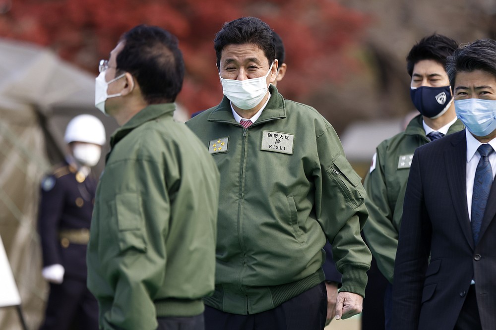 Japan&#x27;s Defense Minister Nobuo Kishi, center, walks as he inspects weapons with Prime Minister Fumio Kishida, left, during a review at the Japan Ground Self-Defense Force Camp Asaka in Tokyo, Japan, Saturday, Nov. 27, 2021. (Kiyoshi Ota/Pool Photo via AP)