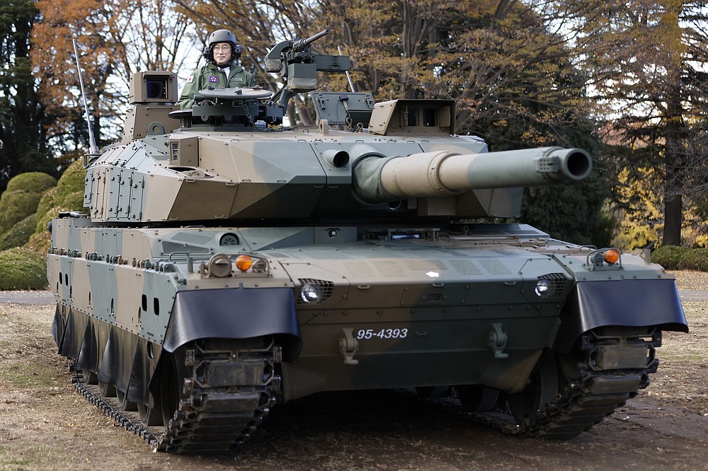 Japan&#x27;s Prime Minister Fumio Kishida rides on a Japan Ground Self-Defense Force (JGSDF) Type 10 tank during a review at the JGSDF Camp Asaka in Tokyo, Japan, Saturday, Nov. 27, 2021. Kishida, at his first troop review Saturday, renewed his pledge to consider &amp;#x201c;all options,&amp;#x201d; including acquiring enemy base strike capability, and vowed to create a stronger Self-Defense Force to protect the country amid growing threats from China and North Korea. (Kiyoshi Ota/Pool Photo via AP)