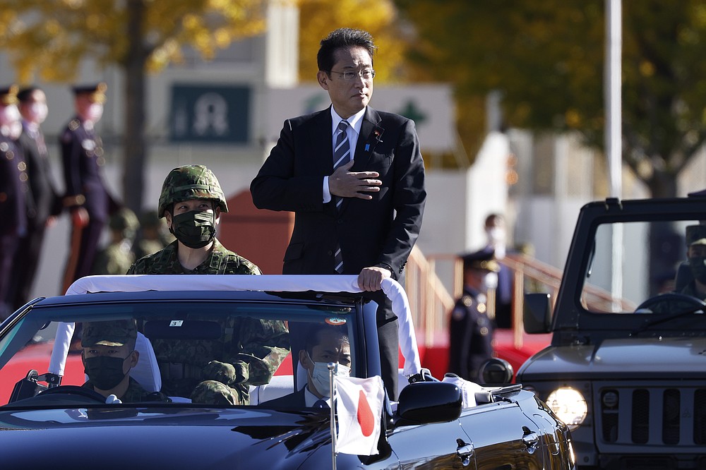 Japan&#x27;s Prime Minister Fumio Kishida, center, stands in a vehicle as he reviews troops of the Japan Self-Defense Forces at the Japan Ground Self-Defense Force Camp Asaka in Tokyo, Japan, Saturday, Nov. 27, 2021. (Kiyoshi Ota/Pool Photo via AP)