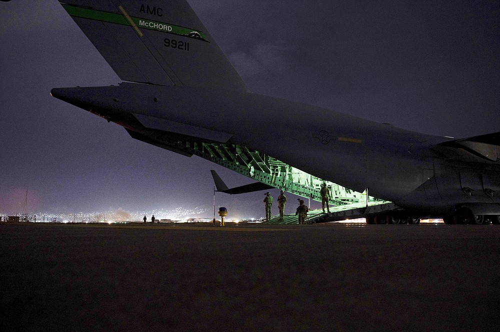 FILE - In this photo provided by the U.S. Air Force, an Air Force aircrew, assigned to the 816th Expeditionary Airlift Squadron, prepares to receive soldiers, assigned to the 82nd Airborne Division, to board a U.S. Air Force C-17 Globemaster III aircraft in support of the final noncombatant evacuation operation missions at Hamid Karzai International Airport in Kabul, Afghanistan on Aug. 30, 2021. The U.S. airlifted 124,000 people out of Kabul over about six weeks as the American-backed Afghan military and government fell to the Taliban. (Senior Airman Taylor Crul/U.S. Air Force via AP, File)