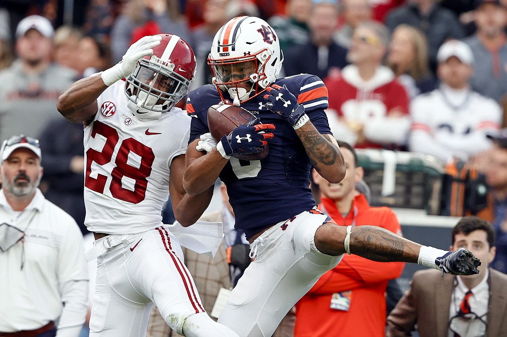 Auburn wide receiver Demetris Robertson (0) catches a pass over Alabama defensive back Josh Jobe (28) during the first half of an NCAA college football game Saturday, Nov. 27, 2021, in Auburn, Ala. (AP Photo/Butch Dill)
