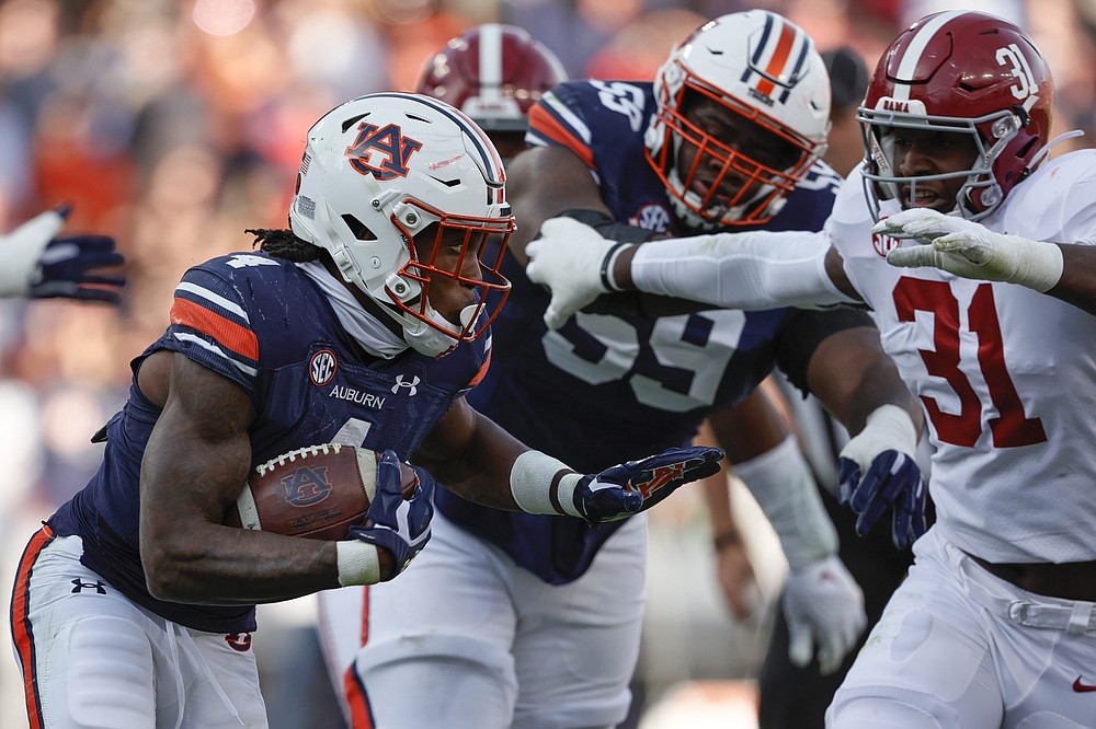 Auburn running back Tank Bigsby (4) carries the ball against Alabama during the first half of an NCAA college football game Saturday, Nov. 27, 2021, in Auburn, Ala. (AP Photo/Butch Dill)