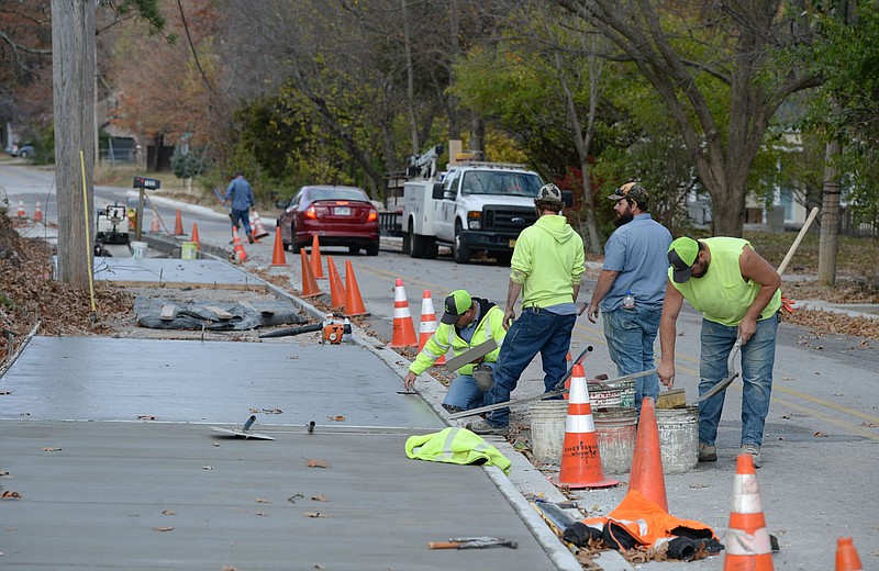 Workers with the city of Fayetteville smooth freshly poured concrete Wednesday while building sidewalks along Mount Comfort Road west of Garland Avenue. City administrators are proposing an extra $1 million in the city's budget next year to build and repair sidewalks, up from the usual $500,000 or so put in annually. Visit nwaonline.com/211128Daily/ for today's photo gallery.
(NWA Democrat-Gazette/Andy Shupe)