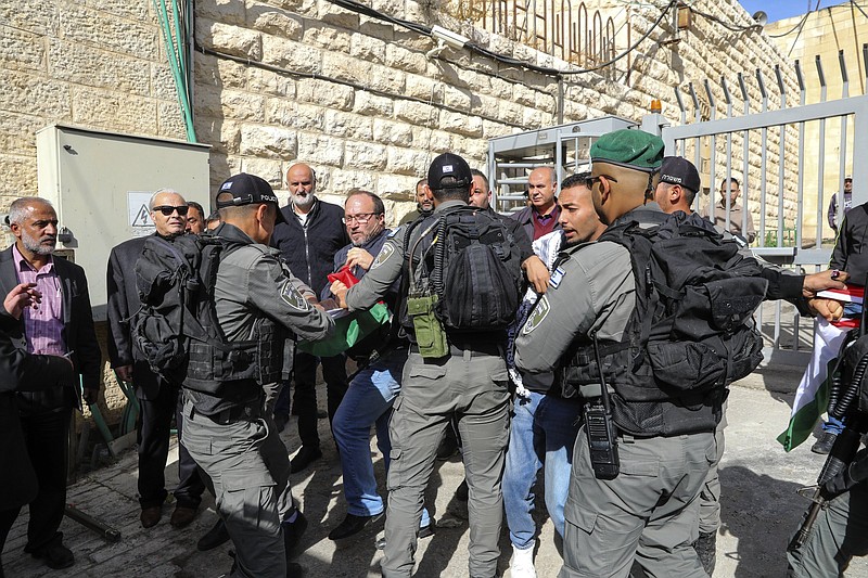 Palestinians scuffle with Israeli forces during a protest against the planned visit of Israeli President Isaac Herzog to Hebron's holiest site, known to Jews as the Tomb of the Patriarchs and to Muslims as the Ibrahimi Mosque in the Israeli controlled part of the West Bank city of Hebron, Sunday, Nov. 28, 2021. (AP Photo/Mahmoud Illean)