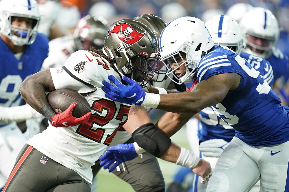 Tampa Bay Buccaneers&#x27; Ronald Jones (27) runs against Indianapolis Colts&#x27; Bobby Okereke (58) during the first half of an NFL football game, Sunday, Nov. 28, 2021, in Indianapolis. (AP Photo/Michael Conroy)