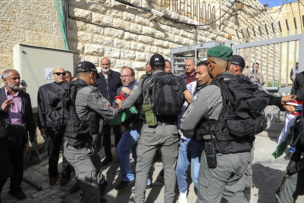 Palestinians scuffle with Israeli forces during a protest against the planned visit of Israeli President Isaac Herzog to Hebron&#x27;s holiest site, known to Jews as the Tomb of the Patriarchs and to Muslims as the Ibrahimi Mosque in the Israeli controlled part of the West Bank city of Hebron, Sunday, Nov. 28, 2021. (AP Photo/Mahmoud Illean)