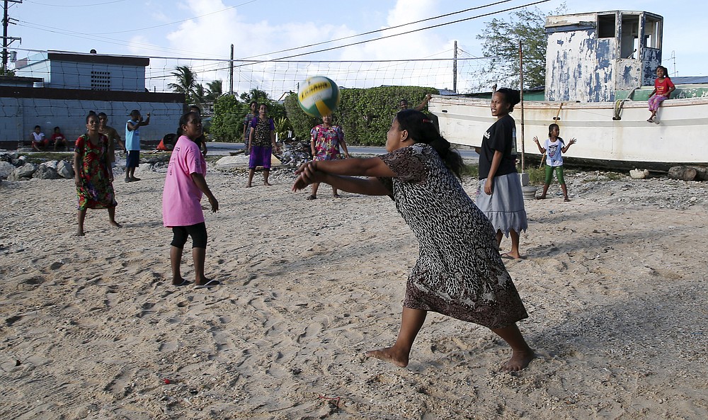 FILE - Mothers and children enjoy an afternoon game of volleyball on a beach in Majuro Atoll in the Marshall Islands on Nov. 9, 2015. For decades, the tiny Marshall Islands has been a stalwart American ally. Its location in the middle of the Pacific Ocean has made it a key strategic outpost for the U.S. military. (AP Photo/Rob Griffith, File)