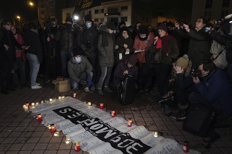 Activists and members of associations defending migrants' rights stand next to a banner reading &quot;309 dead on the France UK border since 1999&quot;, during a gathering outside the port of Calais, northern France, Thursday, Nov. 25, 2021. Children and pregnant women were among at least 27 migrants who died when their small boat sank in an attempted crossing of the English Channel, a French government official said Thursday Nov. 24, 2021. French Interior Minister Gerald Darmanin also announced the arrest of a fifth suspected smuggler thought to have been involved in what was the deadliest migration tragedy to date on the dangerous sea lane. (AP Photo/Rafael Yaghobzadeh)