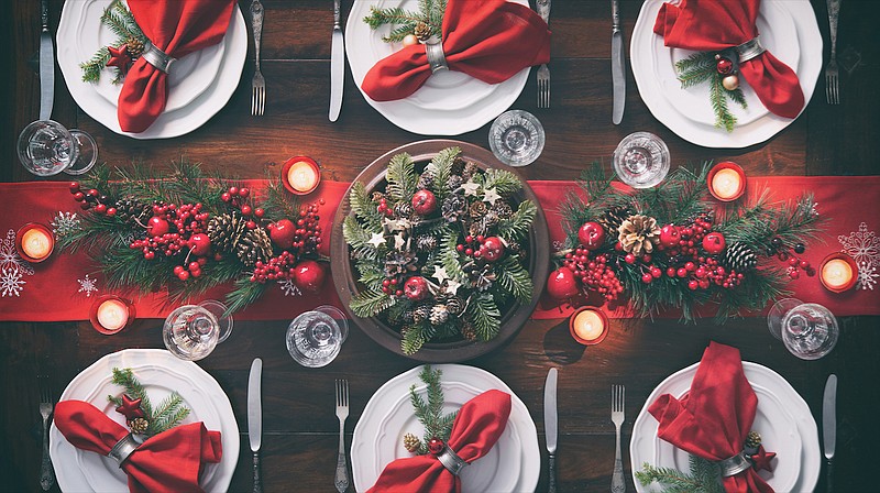 You don’t need holiday-themed tableware. Simple white china, solid-color table linens and clear stemware create the perfect backdrop for a beautiful holiday table. Just add seasonal greenery, a festive centerpiece, and candles. (Courtesy of dreamstime)