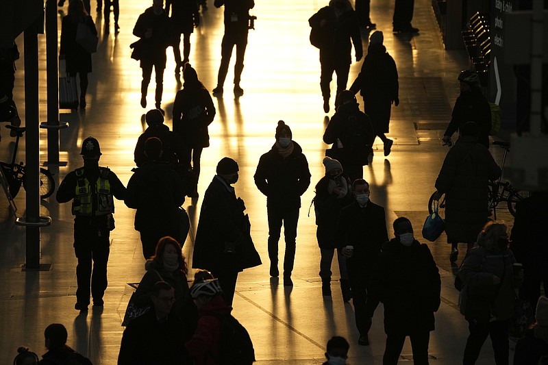 People pass through Waterloo train station, in London, during the morning rush hour, Monday, Nov. 29, 2021. The new potentially more contagious omicron variant of the coronavirus popped up in more European countries on Saturday, just days after being identified in South Africa, leaving governments around the world scrambling to stop the spread. In Britain, Prime Minister Boris Johnson said mask-wearing in shops and on public transport will be required, starting Tuesday. (AP Photo/Matt Dunham)