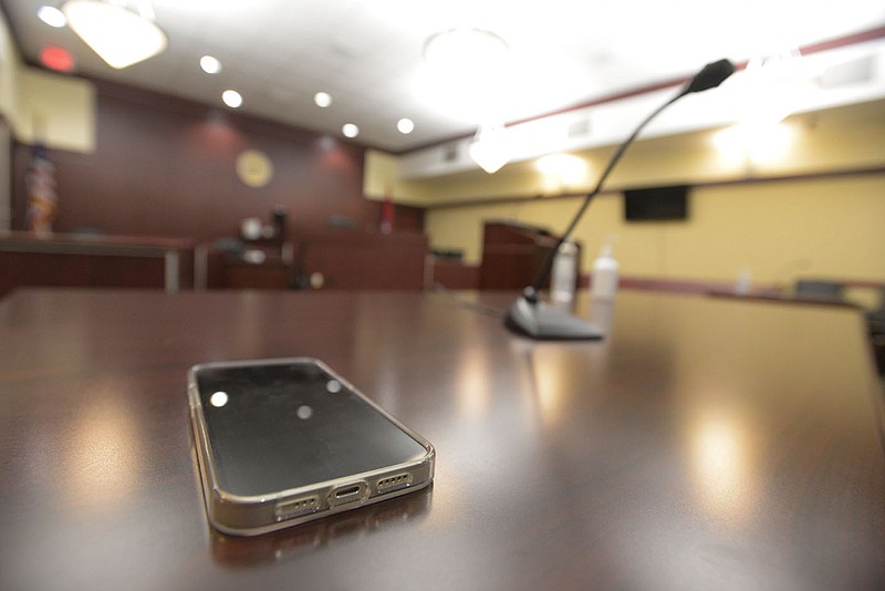 A cellphone is seen on Thursday, Nov. 2, 2021, inside the courtroom of Sebastian County Circuit Judge Gunner DeLay in the Sebastian County Courts Building in Fort Smith. As part of the county?s ongoing efforts to lessen the population at the Sebastian County jail, it is in the process of implementing a new text message notification system designed to remind defendants of court dates they have coming up. Go to nwaonline.com/211205Daily/ to see more photos.
(NWA Democrat-Gazette/Hank Layton)