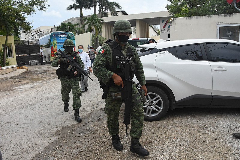 Mexican soldiers walk outside the Hyatt Ziva Riviera hotel in Puerto Morelos, Quintana Roo state, Mexico, on Nov. 4, 2021, after a shooting. The shooting involving rival gangs on a beach near Mexico's Caribbean resort of Cancun left two suspected drug dealers dead, prosecutors said, sparking panic among foreign tourists. (ELIZABETH RUIZ/AFP via Getty Images/TNS)