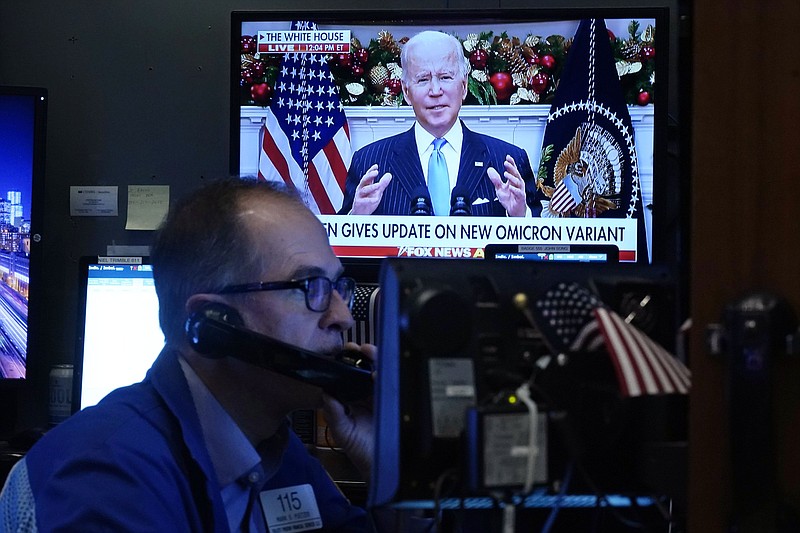 President Jose Biden appears on a screen as trader Mark Puetzer works on the floor of the New York Stock Exchange, Monday, Nov. 29, 2021. President Joe Biden urged Americans to get vaccinated including booster shots as he sought to quell concerns Monday over the new COVID-19 variant omicron. (AP Photo/Richard Drew)