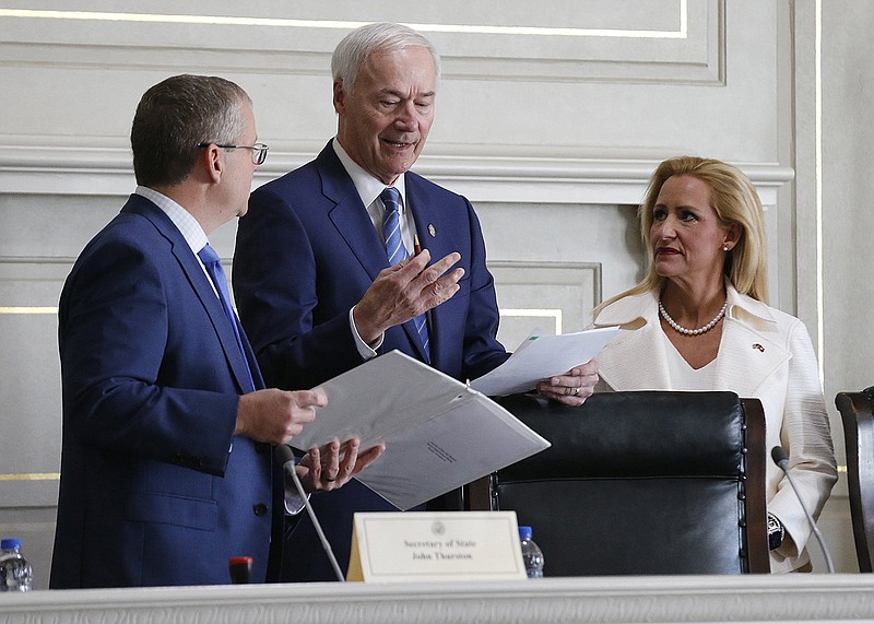 Gov. Asa Hutchinson (center) talks with Secretary of State John Thurston (left) and Attorney General Leslie Rutledge (right) before the Board of Apportionment meeting on Monday, Nov. 29, 2021, at the state Capitol in Little Rock.  
(Arkansas Democrat-Gazette/Thomas Metthe)