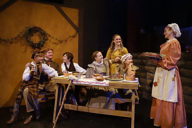 The Cratchit family — (from left) Tiny Tim (Jaydon Clark), Bob (Matthew Maguire), Peter (Aiden Roberson), Belinda (Sarah Grace Stewart), Martha (Annslee Clay), Ann (Julia Dempsey) and Mrs. Cratchit (Claire Hettinger) — are festive for the holiday in “A Christmas Carol” at Argenta Community Theater. (Special to the Democrat-Gazette/Royce West)