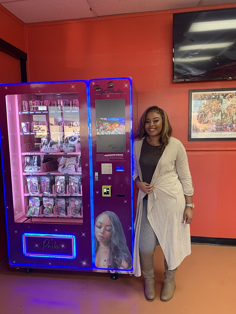 Chelsea Soils with her luxury beauty vending machine located inside Real Kutz and Fadez on Summerhill Road. (Staff photo by Lori Dunn)