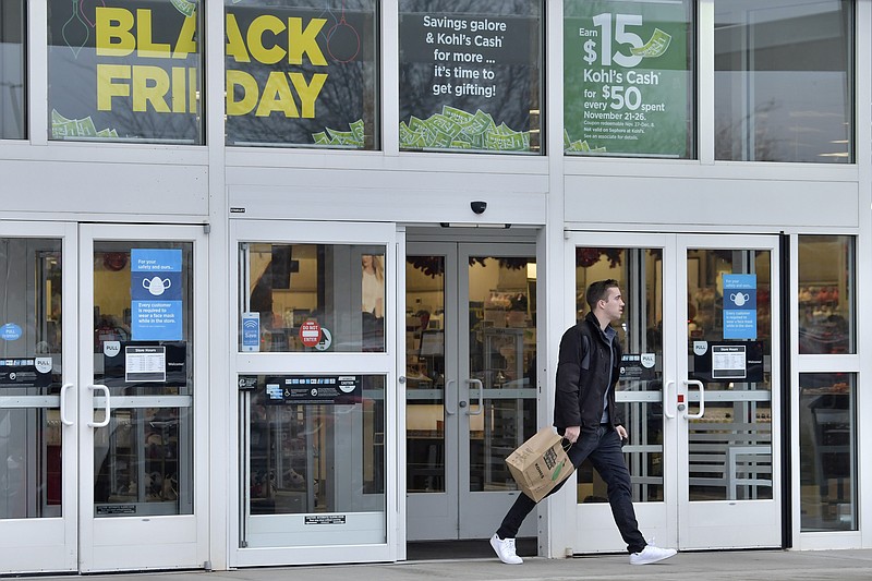 FILE - A shopper emerges from a Kohl's store on Black Friday, on Nov. 26, 2021, in Everett, Mass. U.S. consumer confidence fell to a nine-month low in November, clipped by rising prices and lingering concerns about the coronavirus. The Conference Board reported Tuesday, Nov. 30, 2021 that its consumer confidence index dropped to a reading of 109.5, down from 111.6 in October. (AP Photo/Josh Reynolds)