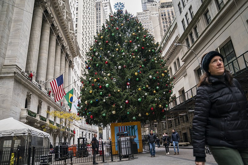 Pedestrians pass a giant Christmas tree erected outside the New York Stock Exchange, Tuesday, Nov. 30, 2021, in New York. (AP Photo/John Minchillo)