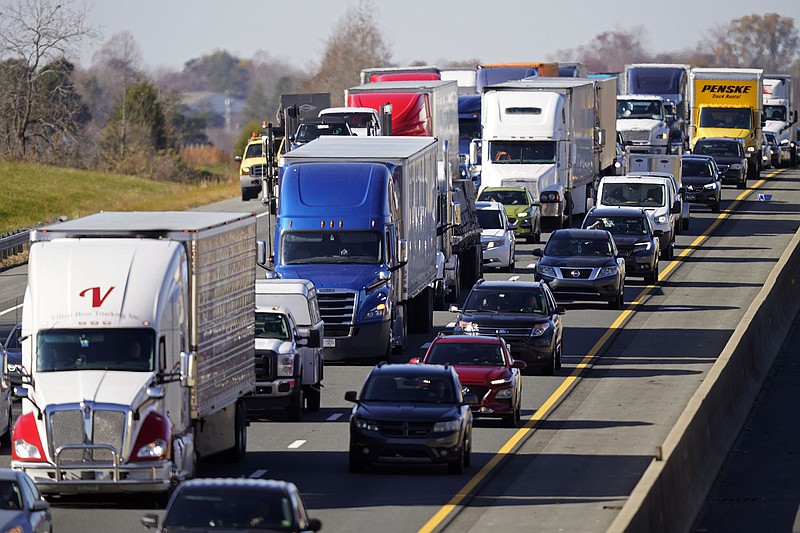 Trucks haul supplies along Interstate 40 near Burlington, N.C., Tuesday, Nov. 30, 2021. Global supply chain shortages continue as high demand has brought goods shortages to the U.S. and much of the world. (AP Photo/Gerry Broome)