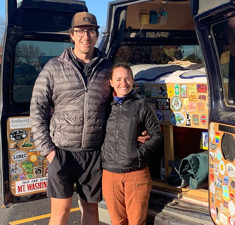 Photographer Tom Woodruff and artist Kate Fleming show the stickers they have collected on their van during their tour of the country for their All 50 States project. They made their last stop in Northwest Arkansas last week. (NWA Democrat-Gazette/Janelle Jessen).