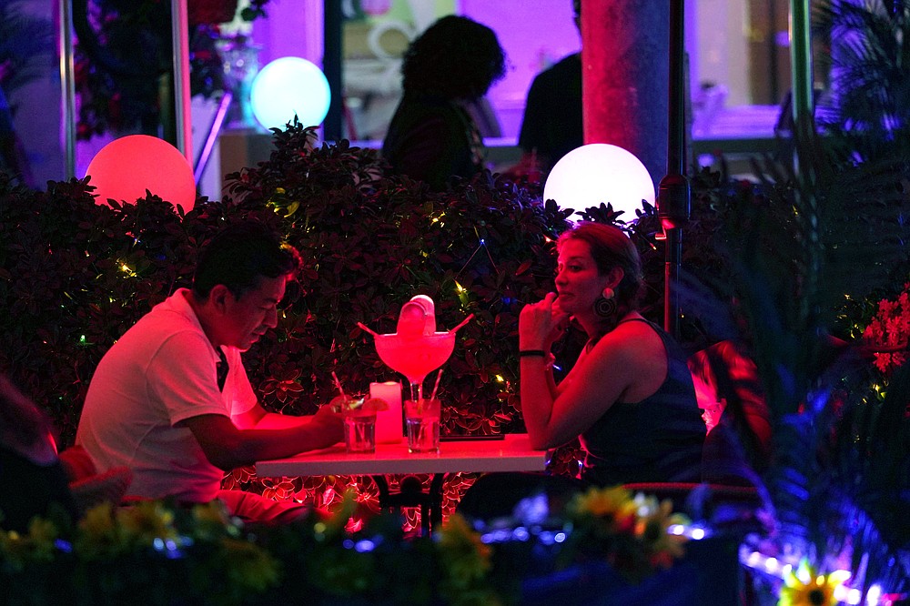 People dine outdoors along Ocean Drive, Friday, Sept. 24, 2021, in Miami Beach, Fla. Cooped-up tourists eager for a taste of Florida&#x27;s sandy beaches, swaying palm trees and warmer climates are visiting the Sunshine State in droves, topping pre-pandemic levels in recent months. (AP Photo/Lynne Sladky)