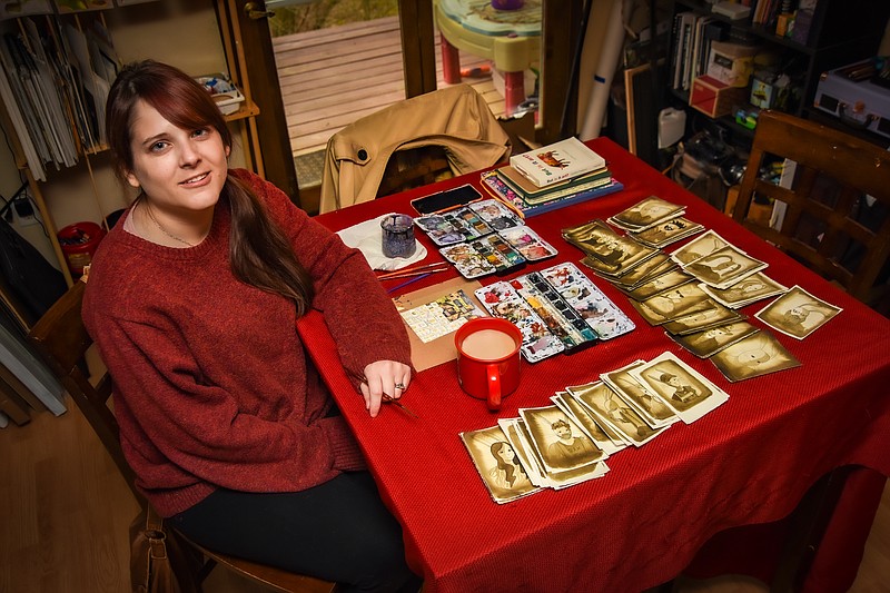 Julie Smith/News Tribune
Lina Forrester is shown seated at her kitchen table, which doubles as her artist work table where she produces watercolor paintings.