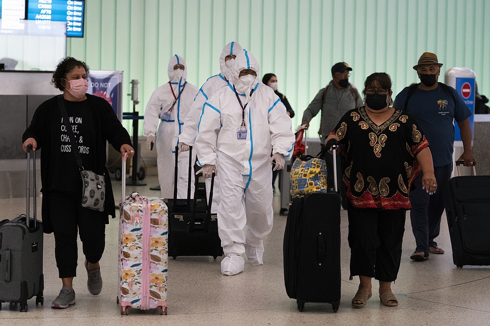 Air China flight crew members in hazmat suits walk through the arrivals area at Los Angeles International Airport in Los Angeles, Tuesday, Nov. 30, 2021. Brazil and Japan joined the rapidly widening circle of countries to report cases of the omicron variant of the coronavirus on Tuesday.&amp;#xa0;(AP Photo/Jae C. Hong)
