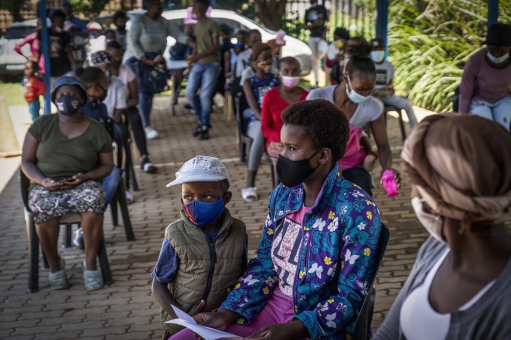 People line up to be vaccinated against COVID-19 in Lawley, south of Johannesburg, South Africa, Wednesday, Dec. 1, 1021. South African doctors say the rapid increase in COVID-19 cases attributed to the new omicron variant is resulting in mostly mild symptoms. (AP Photo/ Shiraaz Mohamed)