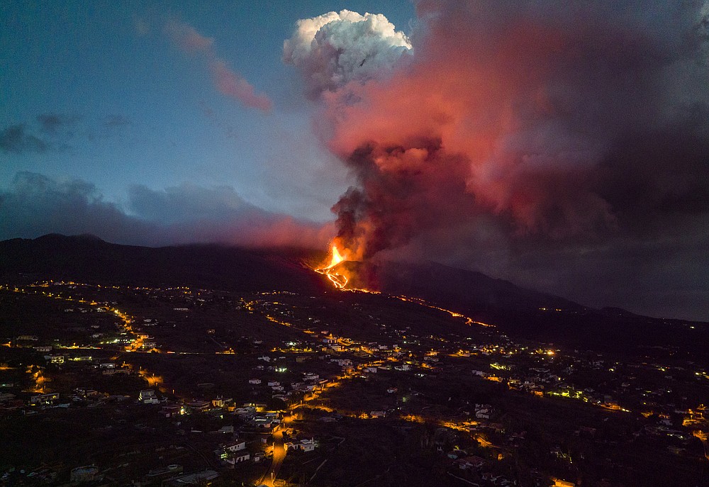 Smoke rises from a volcano on the Canary island of La Palma, Spain, Tuesday, Nov. 30, 2021. Several new volcanic vents opened in La Palma, releasing new lava that flowed fast down a ridge and threatened to widen the impact on evacuated land, infrastructure and homes. (AP Photo/Emilio Morenatti)