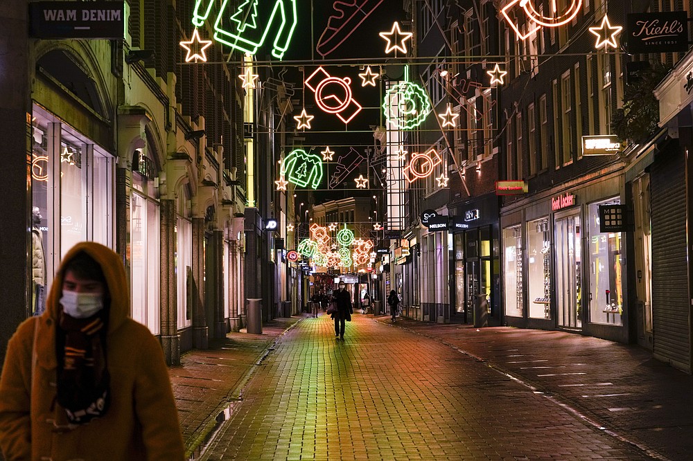 FILE - A view of the capital's shopping streets are near-empty after 5 pm in Amsterdam, Netherlands, Monday, Nov. 29, 2021, after a tougher COVID-19 related lockdown came into effect. The coronavirus's omicron variant kept a jittery world off-kilter Wednesday Dec. 1, 2021, as reports of infections linked to the mutant strain cropped up in more parts of the globe, and one official said that the wait for more information on its dangers felt like “an eternity.” (AP Photo/Peter Dejong, File)