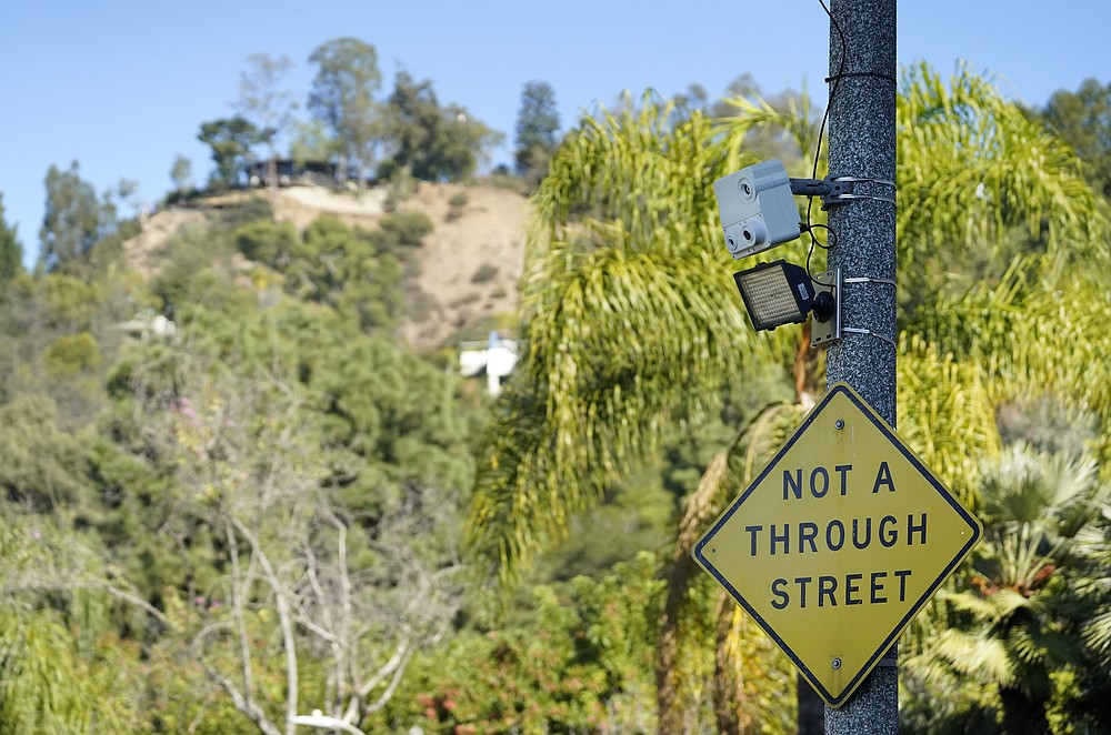 A security camera appears on a telephone pole at the intersection of Maytor Place and Barrie Drive in the Trousdale Estates section of Beverly Hills, Calif., Wednesday, Dec. 1, 2021. Jacqueline Avant, the wife of music legend Clarence Avant, was fatally shot in the neighborhood early Wednesday. (AP Photo/Chris Pizzello)