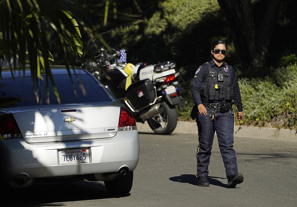 A police officer walks down Maytor Place in the Trousdale Estates section of Beverly Hills, Calif., Wednesday, Dec. 1, 2021. Jacqueline Avant, the wife of music legend Clarence Avant, was fatally shot in the neighborhood early Wednesday. (AP Photo/Chris Pizzello)