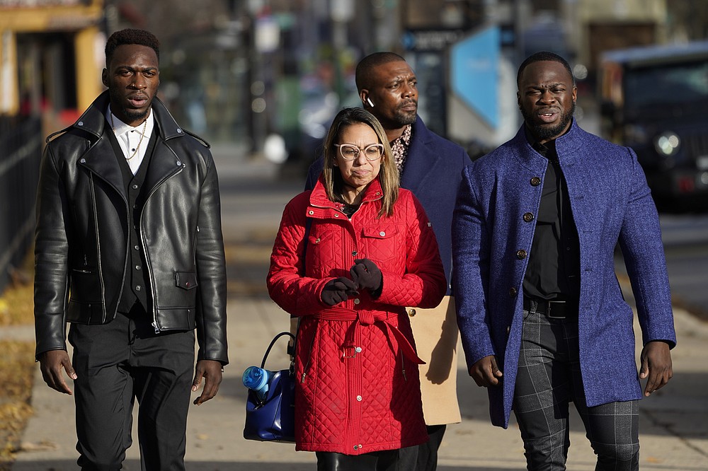 Attorney Gloria Schmidt Rodriguez, center, walks with her clients Abimbola Osundairo, left, and Olabinjo Osundairo, as they arrive at the Leighton Criminal Courthouse to testify in the trial of actor Jussie Smollett Thursday, Dec. 2, 2021, in Chicago. Smollett is accused of lying to police when he reported he was the victim of a racist, anti-gay attack in downtown Chicago nearly three years ago. The man trailing the trio identified himself as a bodyguard. (AP Photo/Charles Rex Arbogast)