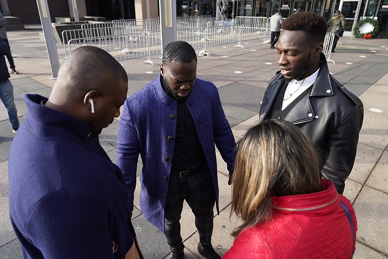 Abimbola Osundairo, right, prays with his brother Olabinjo Osundairo, center, a bodyguard, left, and their attorney Gloria Schmidt Rodriguez, upon their arrival at the Leighton Criminal Courthouse on day four of actor Jussie Smollett's trial Thursday, Dec. 2, 2021, in Chicago. Smollett is accused of lying to police when he reported he was the victim of a racist, anti-gay attack in downtown Chicago nearly three years ago. (AP Photo/Charles Rex Arbogast)