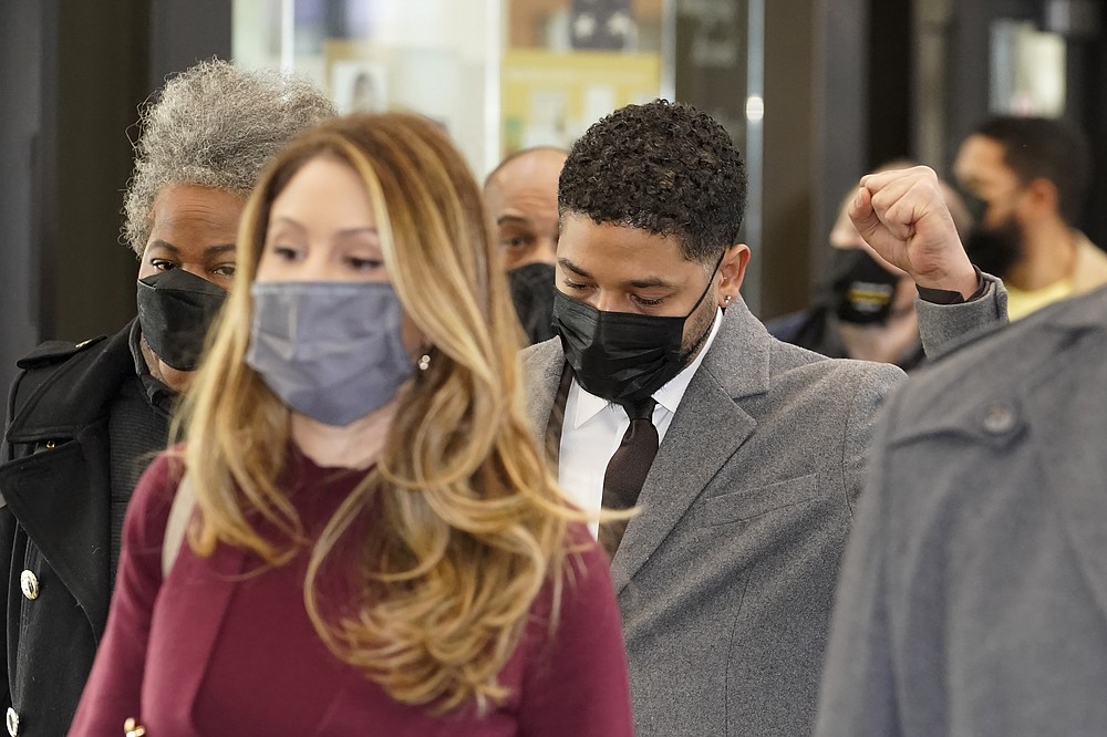 Actor Jussie Smollett raises his fist when asked how he was doing while walking through the Leighton Criminal Courthouse lobby on day four of his trial Thursday, Dec. 2, 2021, in Chicago. Smollett is accused of lying to police when he reported he was the victim of a racist, anti-gay attack in downtown Chicago nearly three years ago. (AP Photo/Charles Rex Arbogast)