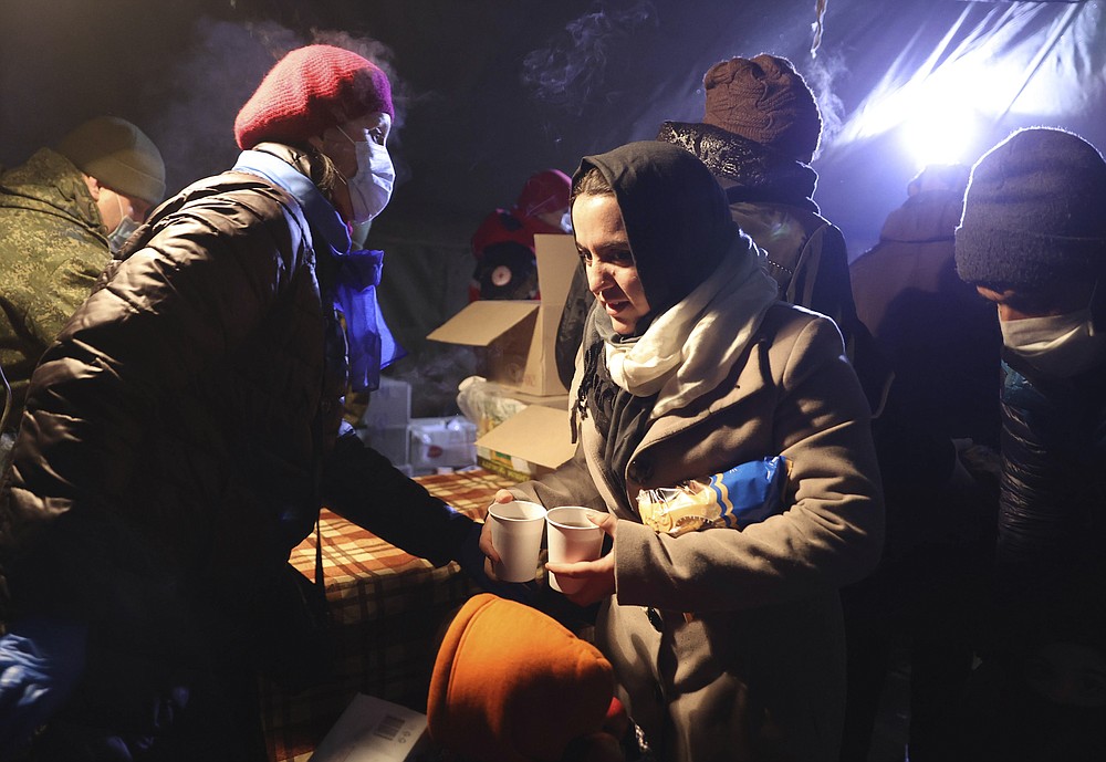 Migrants get a meal in the logistics center of the checkpoint &amp;quot;Bruzgi&amp;quot; at the Belarus-Poland border near Grodno, Belarus, Wednesday, Dec. 1, 2021. The West has accused Belarusian President Alexander Lukashenko of luring thousands of migrants to Belarus with the promise of help to get to Western Europe to use them as pawns to destabilize the 27-nation European Union in retaliation for its sanctions on his authoritarian government. Belarus denies engineering the crisis. (Oksana Manchuk/BelTA via AP)
