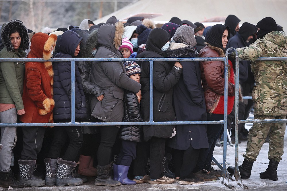 Migrants queue to get hot food in the logistics center of the checkpoint &amp;quot;Bruzgi&amp;quot; at the Belarus-Poland border near Grodno, Belarus, Wednesday, Dec. 1, 2021. The West has accused Belarusian President Alexander Lukashenko of luring thousands of migrants to Belarus with the promise of help to get to Western Europe to use them as pawns to destabilize the 27-nation European Union in retaliation for its sanctions on his authoritarian government. Belarus denies engineering the crisis. (Oksana Manchuk/BelTA via AP)