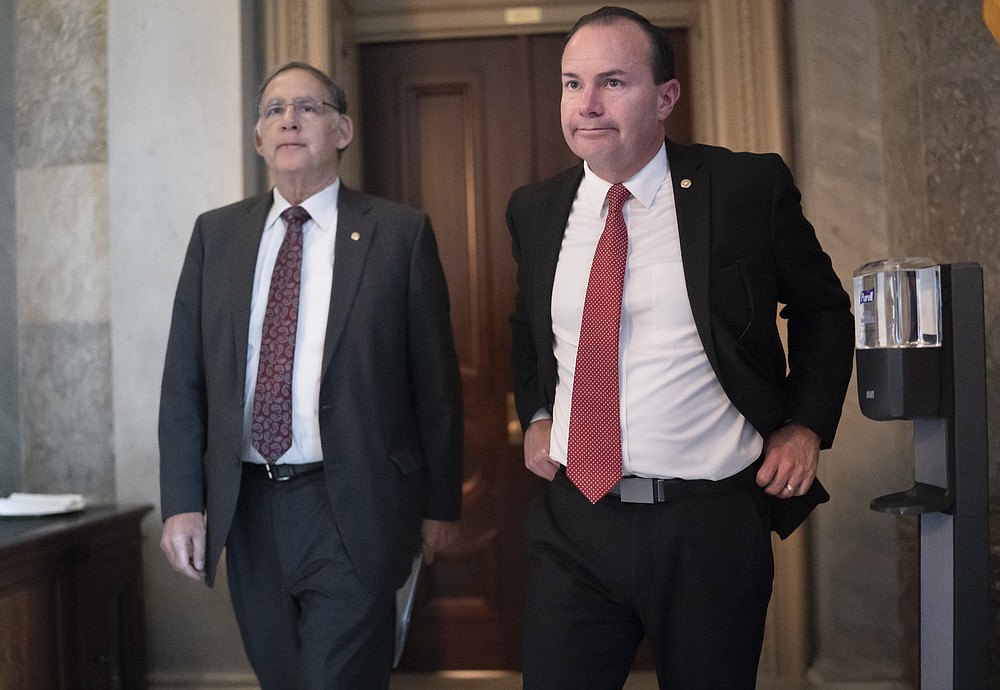 Sen. Mike Lee, R-Utah, joined by Sen. John Boozman, R-Ark., left, leaves a private GOP lunch meeting as he continues to press for a vote on his proposal to barring vaccine mandates that the Biden administration has ordered for U.S. companies, at the Capitol in Washington, Thursday, Dec. 2, 2021. (AP Photo/J. Scott Applewhite)