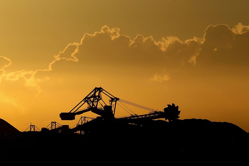 A stacker-reclaimer operates next to stockpiles of coal at the Newcastle Coal Terminal in Newcastle, New South Wales, Australia, on March 26, 2021. MUST CREDIT: Bloomberg photo by Brendon Thorne