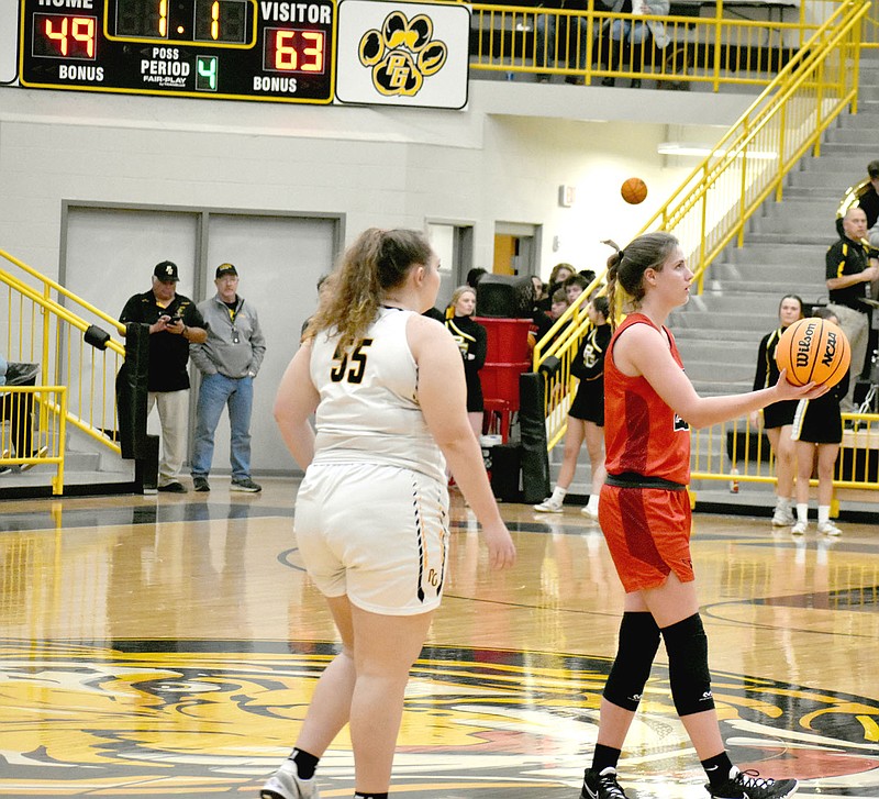 MARK HUMPHREY  ENTERPRISE-LEADER/Picture of sportsmanship. Farmington junior Jenna Lawrence hands the ball to a referee with time expiring and the scoreboard displaying the final score, 63-49, of the Lady Cardinals' road win at rival Prairie Grove on Tuesday, Jan. 4.