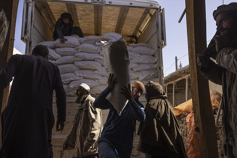 Laborers unload sacks of flour from a World Food Program convoy that traveled from Kabul to Afghanistan’s Tagab district, Oct. 27, 2021. An estimated 22.8 million people — more than half the population of Afghanistan — are expected to face potentially life-threatening food insecurity this winter. Many are already on the brink of catastrophe. (Victor J. Blue/The New York Times)