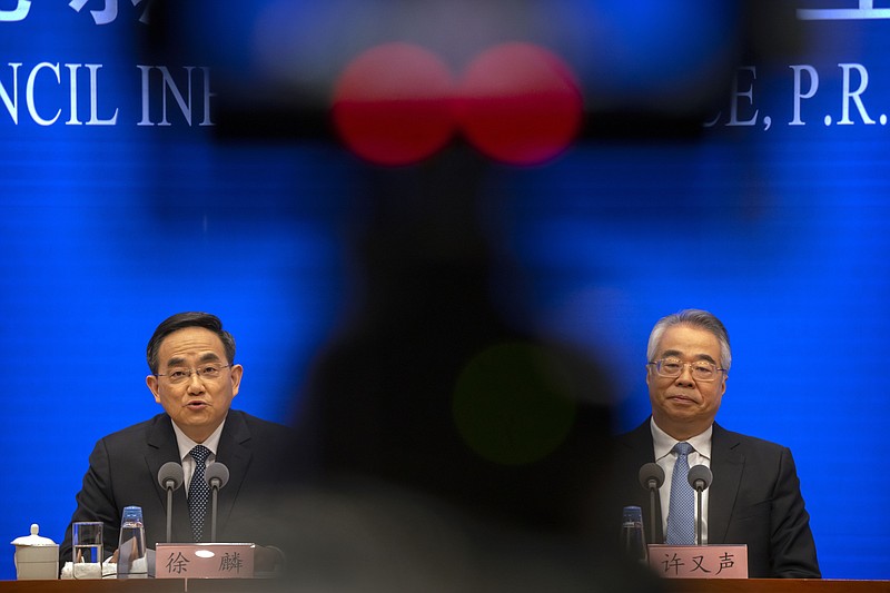 Xu Lin, left, vice minister of the Publicity Department of the Central Committee of China's Communist Party, speaks as Xu Yousheng, vice minister of the United Front Work Department of the Central Committee listens during a press conference at the State Council Information Office in Beijing, Saturday, Dec. 4, 2021. China's Communist Party took American democracy to task on Saturday, sharply criticizing a global democracy summit being hosted by President Joe Biden next week and extolling the virtues of its governing system. (AP Photo/Mark Schiefelbein)