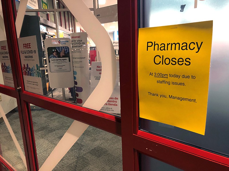 A sign is posted outside a CVS pharmacy on Thursday, Dec. 2, 2021 in Indianapolis. A rush of vaccine-seeking customers and staff shortages are squeezing drugstores around the country. That has led to frazzled workers and even temporary pharmacy closures.    (AP Photo/Tom Murphy)