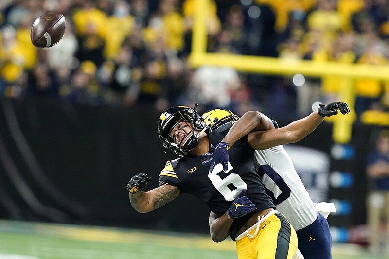 Michigan defensive back Daxton Hill, rear, breaks up a pass intended for Iowa wide receiver Keagan Johnson (6) during the first half of the Big Ten championship football game Saturday in Indianapolis. Hill was called for pass interference on the play. – Photo by Darron Cummings of The Associated Press