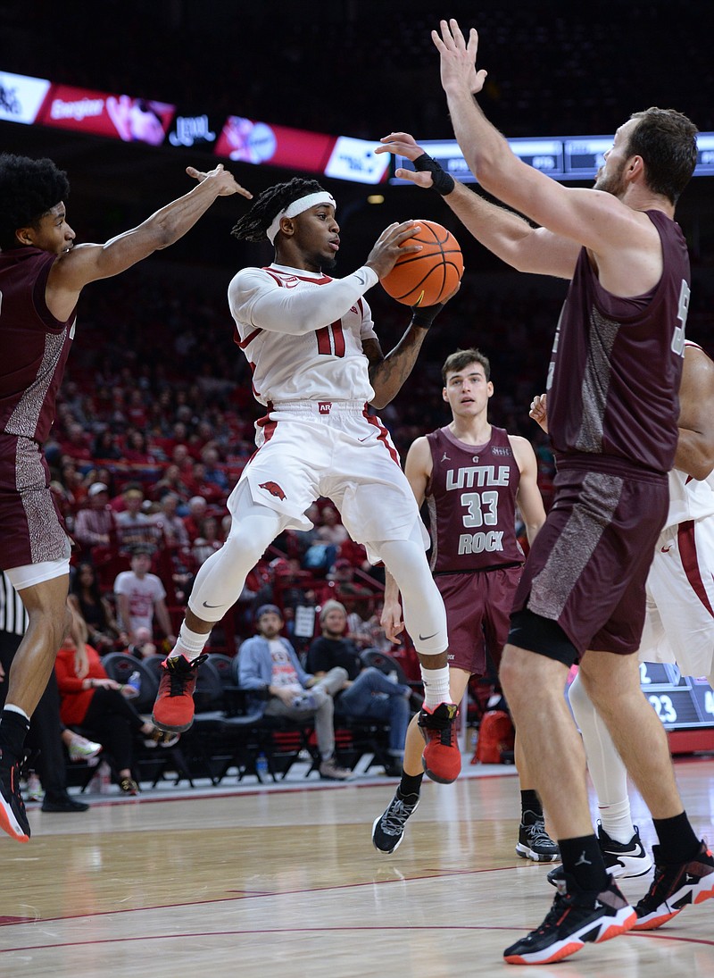 Arkansas guard Chris Lykes (11) passes out of the lane Saturday as he is pressured by Little Rock guard D.J. Smith, left, and center Admir Besovic, right, during the second half of the Razorbacks' 93-78 win in Bud Walton Arena in Fayetteville. - Photo by Andy Shupe of NWA Democrat-Gazette