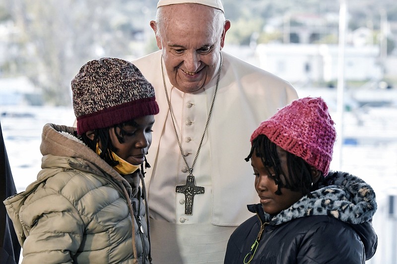 Pope Francis greets children during a ceremony at the Karatepe refugee camp, on the northeastern Aegean island of Lesbos, Greece, Sunday, Dec. 5, 2021. Pope Francis is offering comfort migrants at a refugee camp on the Greek island of Lesbos. He is blasting what he says is the indifference and self-interest shown by Europe &quot;that condemns to death those on the fringes.&quot; (Louisa Gouliamaki/Pool via AP)