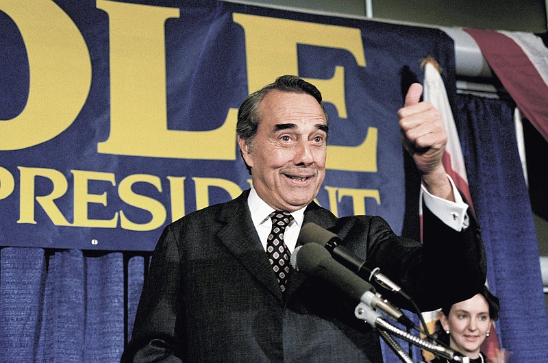 FILE - Republican presidential candidate Sen. Robert Dole R-Kan., gestures while making a speech in Washington, March 28, 1988. Bob Dole, who overcame disabling war wounds to become a sharp-tongued Senate leader from Kansas, a Republican presidential candidate and then a symbol and celebrant of his dwindling generation of World War II veterans, has died. He was 98. His wife, Elizabeth Dole, posted the announcement Sunday, Dec. 5, 2021, on Twitter.  (AP Photo/Ron Edmonds, File)