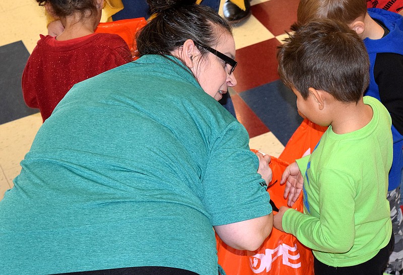 Westside Eagle Observer/MIKE ECKELS
Alicia Morrow (left) helps a student look at a pair of new shoes he just received during the Thursday morning Samaritan's Feet International's Shoes 4 Kids program at Northside Elementary in Decatur.